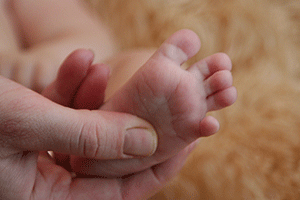 Разводит пальчики младенец